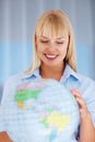 Smiling international executive. Young business woman holding globe. Royalty Free Stock Photo