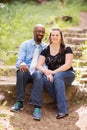 Smiling Interracial Couple Sitting Outside