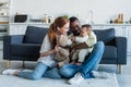 smiling interracial parents sitting on floor