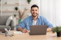 Smiling israeli man working on laptop at home