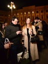 Smiling italian young woman and British photographers tripod a , interesting kissing coupla on background