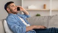 Smiling jew man working and talking on phone at home