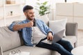 Smiling jewish man watching video on computer, drinking hot coffee