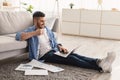 Smiling jewish man watching video on pc, drinking hot coffee