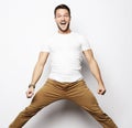 Smiling joyful man jumping on a white background.