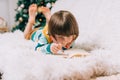 Smiling Kid boy lying on couch and writing the letter to dear Santa at home near Christmas tree. Child wish list. Dreams Royalty Free Stock Photo