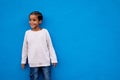 Smiling kid boy portrait. Little african american child boy posing on blue background, wall Royalty Free Stock Photo