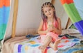 Smiling kid with dreadlocks in tent. Girl playing in tent. Child camping. Having fun outdoors at campground.