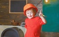 Smiling kid holding spanner and pointing up with his finger. Cute boy having fun in workshop. Little builder wearing Royalty Free Stock Photo