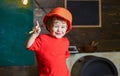 Smiling kid holding spanner and pointing up with his finger. Cute boy having fun in workshop. Little builder wearing Royalty Free Stock Photo