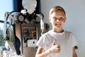 Smiling kid showing thumbs up near human robot