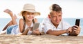 Smiling kids on beach with phone in hands Royalty Free Stock Photo