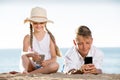 Smiling kids on beach with phone in hands Royalty Free Stock Photo