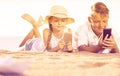 Smiling kids on beach with phone in hands Royalty Free Stock Photo