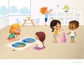 Smiling kids doing different tasks at primary school. Boys and girls building pyramid out of pink blocks and viewing Royalty Free Stock Photo