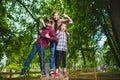 Smiling kids having fun at playground. Children playing outdoors in summer. Teenagers riding on a swing outside