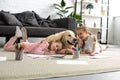 smiling kids lying on floor together with golden retriever dog