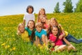 Smiling kids sitting together on the green grass Royalty Free Stock Photo