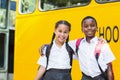 Smiling kids standing in front of school bus Royalty Free Stock Photo
