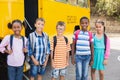 Smiling kids standing together in front of school bus Royalty Free Stock Photo