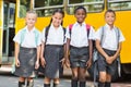 Smiling kids standing together in front of school bus Royalty Free Stock Photo