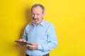 smiling kind senior man holding a tablet in his hands