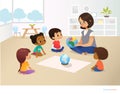 Smiling kindergarten teacher shows globe to children sitting in circle during geography lesson. Preschool activities Royalty Free Stock Photo