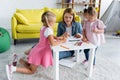 smiling kindergarten teacher talking with preschooler