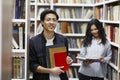 Smiling korean guy holding textbooks at campus library Royalty Free Stock Photo