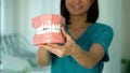 Smiling lady dentist holding jaw model, professional services, healthy teeth