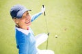 Smiling lady golfer kneeling on the putting green Royalty Free Stock Photo