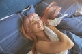 Smiling lady with stylish pink hair rests in large bed in lazy morning