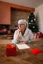 Smiling lady thinking and writing a letter for Christmas Royalty Free Stock Photo