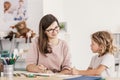 Smiling language tutor working with a little boy, drawing with c Royalty Free Stock Photo