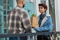 Smiling large handsome florist and owner of floral store he giving to the customer woman some plants on the eco bag he