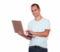 Smiling latin adult man using his laptop computer