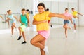 Smiling latin american preteen girl training vigorous dance with tweens