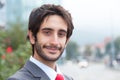 Smiling latin businessman with beard in front of his office