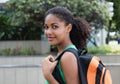 Smiling latin female student with bag in the city