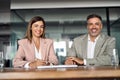 Smiling Latin mature business man and woman sitting in office, portrait. Royalty Free Stock Photo