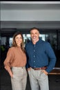 Smiling Latin mid aged business man and woman in office, vertical portrait. Royalty Free Stock Photo