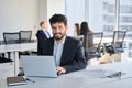 Smiling Latin young business man employee sitting at work with laptop. Royalty Free Stock Photo