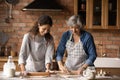 Smiling Latino mom and daughter bake in kitchen Royalty Free Stock Photo