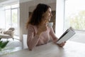 Smiling Latino woman drink coffee read book at home Royalty Free Stock Photo