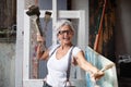 smiling laughing happy older mature woman portrait, proud artist, in her fifties with grey hair and black glasses, with a positive Royalty Free Stock Photo