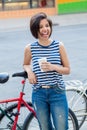 Smiling laughing young hipster latin colombian girl woman with short hair bob in blue ripped jeans Royalty Free Stock Photo