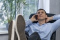 Smiling lazy man feet up on desk talking on the phone. Happy young director is resting with his feet on the table Royalty Free Stock Photo