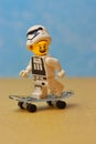 Smiling lego figurine with a stormtrooper helmet riding on a skateboard