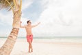 Smiling lifeguard leaning on a palm tree Royalty Free Stock Photo