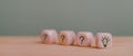 Smiling light bulb on wooden cube with other blurred question cubes for good idea, best selection, best solution, brain storm Royalty Free Stock Photo